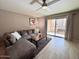 Inviting living room with a plush gray couch, wooden floors, and a sliding glass door to the balcony at 7920 E Camelback Rd # 203, Scottsdale, AZ 85251