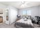 Bedroom featuring a gray bedspread, a ceiling fan, neutral walls, and a view of the en suite bathroom at 8637 W Kathleen Rd, Peoria, AZ 85382