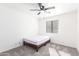 Minimalist bedroom with neutral walls, a ceiling fan, a simple wood bed frame, and a small window at 8637 W Kathleen Rd, Peoria, AZ 85382