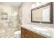 Bathroom features a tiled walk-in shower with granite countertops, vanity, and framed mirror at 8804 E Sunnyside Dr, Scottsdale, AZ 85260