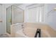 Cozy bathroom featuring a bathtub with a shower and a window, perfect for relaxation at 9818 W Pontiac Dr, Peoria, AZ 85382
