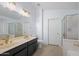 Bright bathroom with double sinks, modern fixtures, and a glass-enclosed shower and bathtub at 9818 W Pontiac Dr, Peoria, AZ 85382