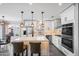 Bright kitchen boasts white cabinets, an island with seating, and stainless steel appliances at 9818 W Pontiac Dr, Peoria, AZ 85382