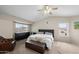 Spacious main bedroom with a ceiling fan, natural light, and a charming seating area at 9818 W Pontiac Dr, Peoria, AZ 85382
