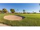 A sand trap and fairway are surrounded by green grass and desert vegetation at 10815 W Hatcher Rd, Sun City, AZ 85351