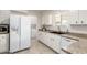 Bright kitchen featuring modern appliances, white cabinetry, and a view to laundry area at 10815 W Hatcher Rd, Sun City, AZ 85351