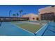 View of blue and green pickleball courts with palm trees and shade structure at 10815 W Hatcher Rd, Sun City, AZ 85351