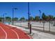 Outdoor running track and basketball courts in a recreation area with mature trees at 10815 W Hatcher Rd, Sun City, AZ 85351