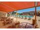 A large outdoor pool and deck area covered by a canopy, surrounded by seating and landscaping at 10815 W Hatcher Rd, Sun City, AZ 85351