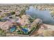 Stunning aerial view of a lakeside home featuring a private pool, lush landscaping, and access to the water at 11101 W Sieno Pl, Avondale, AZ 85392