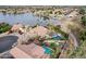 Drone shot highlighting a beautiful home with pool, lush landscaping and lake access at 11101 W Sieno Pl, Avondale, AZ 85392