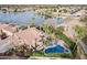 Aerial view showcases a luxurious home with a private pool, manicured landscaping, and serene lake access at 11101 W Sieno Pl, Avondale, AZ 85392