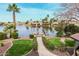 Scenic view of the lakefront property with a lush green lawn and private dock at 11101 W Sieno Pl, Avondale, AZ 85392