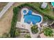 Aerial view of a luxurious pool with spa, stone decking, umbrellas, and meticulously kept landscaping at 11101 W Sieno Pl, Avondale, AZ 85392