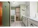 Charming bathroom with a glass-enclosed shower, wood look floors, and custom vanity with storage at 11101 W Sieno Pl, Avondale, AZ 85392