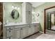 Bright bathroom featuring double sinks, wood-look floors, marble countertop and custom cabinets at 11101 W Sieno Pl, Avondale, AZ 85392