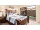 Cozy bedroom featuring a rustic wooden bed frame and access to the patio at 11101 W Sieno Pl, Avondale, AZ 85392