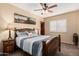 Cozy bedroom with a rustic wood frame bed, ceiling fan, and a shuttered window at 11101 W Sieno Pl, Avondale, AZ 85392