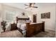 Bedroom featuring a rustic wood frame bed, ceiling fan, and a shuttered window at 11101 W Sieno Pl, Avondale, AZ 85392