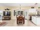 Dining area with large table, shuttered windows, and modern appliances at 11101 W Sieno Pl, Avondale, AZ 85392