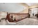Upper level hallway with wood railing overlooking the living room and access to bedrooms at 11101 W Sieno Pl, Avondale, AZ 85392