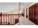 Hallway leading to the bedrooms on the upper level, boasting wood railing and light hardwood-style flooring at 11101 W Sieno Pl, Avondale, AZ 85392