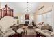 Open living room bathed in light featuring fireplace, clerestory windows, and dark hardwood floors at 11101 W Sieno Pl, Avondale, AZ 85392