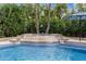 Stunning pool with waterfall feature, palm trees, and manicured landscaping creating an outdoor oasis at 11101 W Sieno Pl, Avondale, AZ 85392