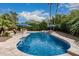 A swimming pool surrounded by lush landscaping and palm trees at 11101 W Sieno Pl, Avondale, AZ 85392