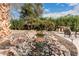 Backyard rock water feature with gentle waterfall adds tranquility and natural beauty to this lushly landscaped outdoor space at 11101 W Sieno Pl, Avondale, AZ 85392