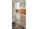 Elegant bathroom with light wood vanity, decorative tiled accents, and glass block window for natural light at 15342 W Tasha Dr, Surprise, AZ 85374
