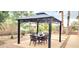 Covered patio area offers a perfect space for outdoor dining and relaxation with mature landscaping at 15342 W Tasha Dr, Surprise, AZ 85374