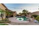 Backyard featuring swimming pool with rock waterfall, desert landscaping and patio with string lights at 15430 W Sells Dr, Goodyear, AZ 85395