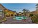 Beautiful backyard showcasing a stunning pool and spa area, surrounded by lush landscaping and ambient string lighting at 15430 W Sells Dr, Goodyear, AZ 85395