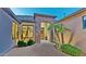 Charming front entryway featuring a decorative door, desert landscaping, and a beautiful stone archway at 15430 W Sells Dr, Goodyear, AZ 85395