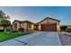Beautiful exterior showcasing a well-manicured lawn, mature trees, and a wide driveway leading up to an attached two-car garage at 15430 W Sells Dr, Goodyear, AZ 85395