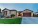 Stunning single-Gathering home features a lush front yard, charming desert landscaping, and a spacious driveway leading to a two-car garage at 15430 W Sells Dr, Goodyear, AZ 85395