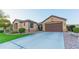Inviting home featuring manicured lawn, desert landscaping, and a two-car attached garage at 15430 W Sells Dr, Goodyear, AZ 85395