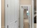 Bright hallway featuring white paneled doors leading to a bedroom with neutral walls and carpet at 15430 W Sells Dr, Goodyear, AZ 85395