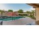 Inviting swimming pool with rock waterfall feature, red umbrella, and desert landscaping at 15430 W Sells Dr, Goodyear, AZ 85395