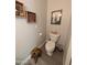 Cozy powder room featuring a toilet, artistic wall decorations, and a wooden stool for added charm and functionality at 170 E Guadalupe Rd # 154, Gilbert, AZ 85234