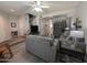 Open-concept living room with laminate floors, comfortable grey seating, and ample natural light at 170 E Guadalupe Rd # 154, Gilbert, AZ 85234