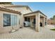 Exterior view of the home featuring a covered patio, brick paving, and well-maintained landscaping at 17094 N Silver Path, Surprise, AZ 85374