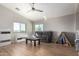 Bright living room with a ceiling fan and a large window offering natural light at 19084 N Toledo Ave, Maricopa, AZ 85138