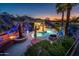 Aerial view of a stunning backyard featuring a pool, spa, outdoor kitchen, firepit and landscaped gardens at sunset at 19644 N Majestic Vista Ct, Surprise, AZ 85387