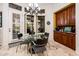 Bright dining area with a glass table, modern chandelier, and built-in cabinetry at 19644 N Majestic Vista Ct, Surprise, AZ 85387