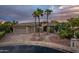 Elegant home exterior featuring mature palms, a three-car garage, and stone accents at 19644 N Majestic Vista Ct, Surprise, AZ 85387