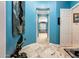 Hallway with arched entry and blue walls, featuring a mermaid statue and artistic decor at 19644 N Majestic Vista Ct, Surprise, AZ 85387