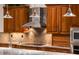 Elegant kitchen showcasing rich wood cabinets, stone countertops, and stainless steel appliances at 19644 N Majestic Vista Ct, Surprise, AZ 85387