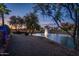 Picturesque pond view showcasing a fountain, mature trees, and desert landscaping at twilight at 19644 N Majestic Vista Ct, Surprise, AZ 85387